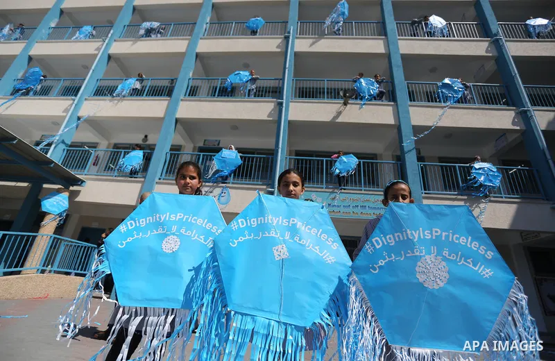 Palestinian schoolgirls fly kites during a protest against US aid cuts to mark the seventh anniversary of the Tohoku earthquake and tsunami that left more than 18,500 people dead or missing, at a school belonging to the...