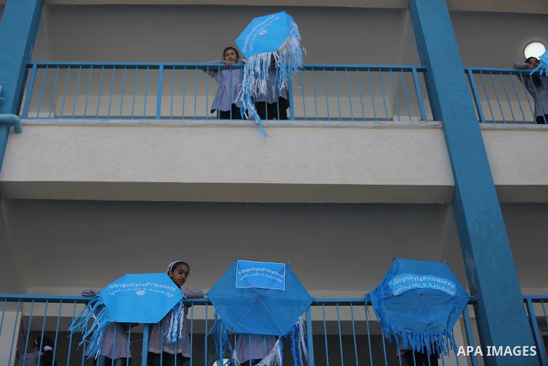 Palestinian schoolgirls fly kites during a protest against US aid cuts to mark the seventh anniversary of the Tohoku earthquake and tsunami that left more than 18,500 people dead or missing, at a school belonging to the...