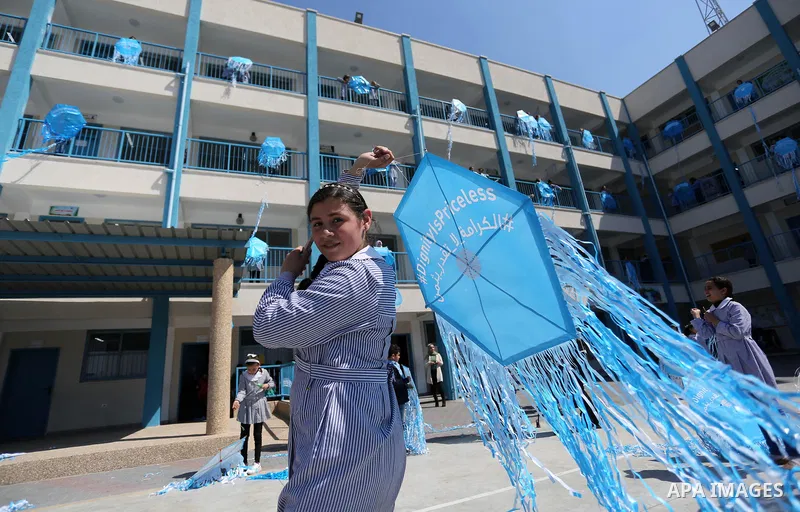 Palestinian schoolgirls fly kites during a protest against US aid cuts to mark the seventh anniversary of the Tohoku earthquake and tsunami that left more than 18,500 people dead or missing, at a school belonging to the...