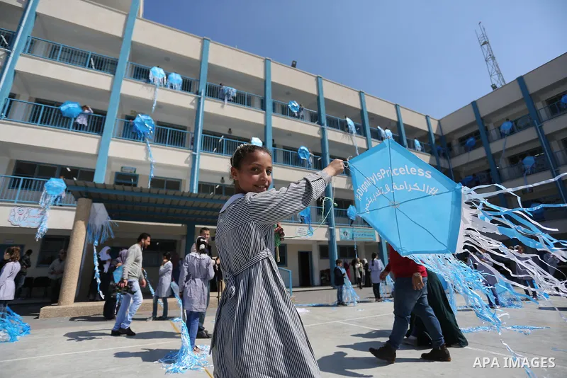 Palestinian schoolgirls fly kites during a protest against US aid cuts to mark the seventh anniversary of the Tohoku earthquake and tsunami that left more than 18,500 people dead or missing, at a school belonging to the...
