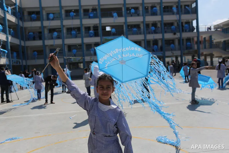 Palestinian schoolgirls fly kites during a protest against US aid cuts to mark the seventh anniversary of the Tohoku earthquake and tsunami that left more than 18,500 people dead or missing, at a school belonging to the...
