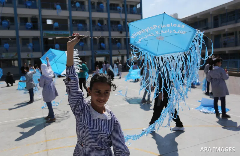 Palestinian schoolgirls fly kites during a protest against US aid cuts to mark the seventh anniversary of the Tohoku earthquake and tsunami that left more than 18,500 people dead or missing, at a school belonging to the...
