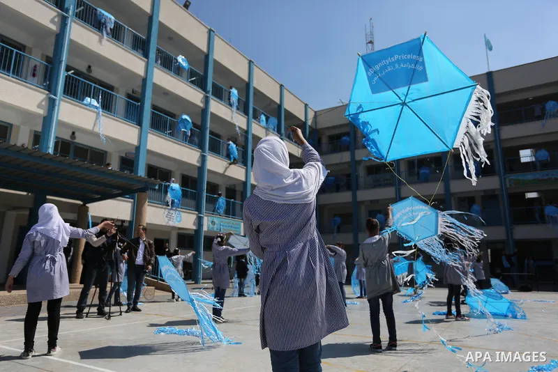 Palestinian schoolgirls fly kites during a protest against US aid cuts to mark the seventh anniversary of the Tohoku earthquake and tsunami that left more than 18,500 people dead or missing, at a school belonging to the...