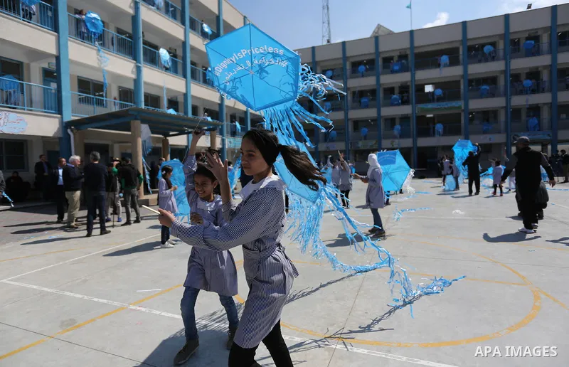 Palestinian schoolgirls fly kites during a protest against US aid cuts to mark the seventh anniversary of the Tohoku earthquake and tsunami that left more than 18,500 people dead or missing, at a school belonging to the...