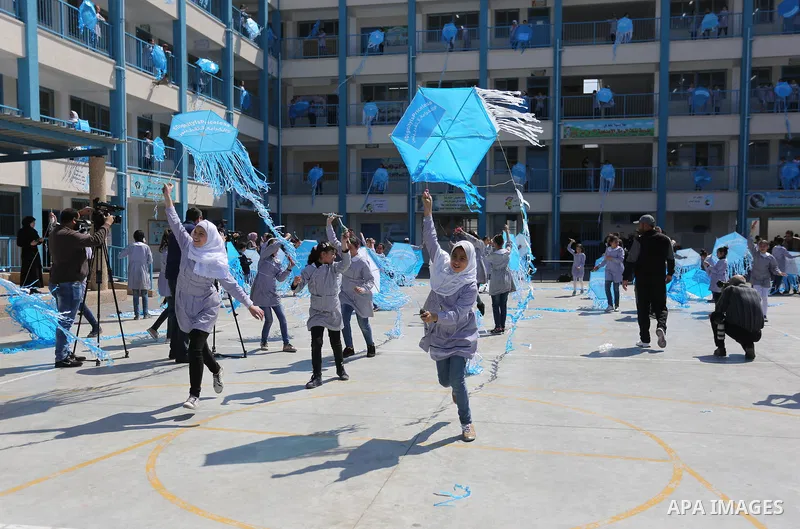 Palestinian schoolgirls fly kites during a protest against US aid cuts to mark the seventh anniversary of the Tohoku earthquake and tsunami that left more than 18,500 people dead or missing, at a school belonging to the...