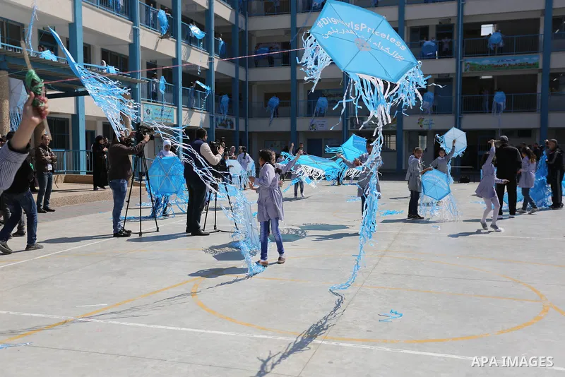 Palestinian schoolgirls fly kites during a protest against US aid cuts to mark the seventh anniversary of the Tohoku earthquake and tsunami that left more than 18,500 people dead or missing, at a school belonging to the...