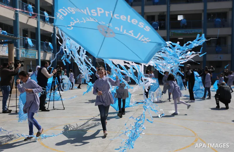 Palestinian schoolgirls fly kites during a protest against US aid cuts to mark the seventh anniversary of the Tohoku earthquake and tsunami that left more than 18,500 people dead or missing, at a school belonging to the...