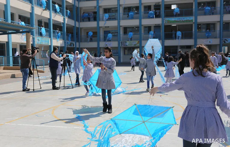Palestinian schoolgirls fly kites during a protest against US aid cuts to mark the seventh anniversary of the Tohoku earthquake and tsunami that left more than 18,500 people dead or missing, at a school belonging to the...