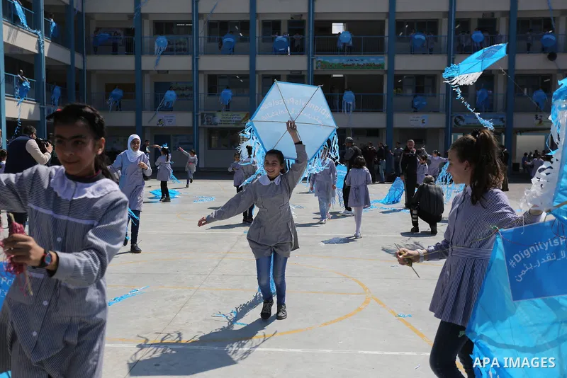 Palestinian schoolgirls fly kites during a protest against US aid cuts to mark the seventh anniversary of the Tohoku earthquake and tsunami that left more than 18,500 people dead or missing, at a school belonging to the...