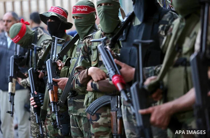 Palestinian militants of the National Resistance brigades, the armed wing of the Democratic Front for the Liberation of Palestine (DFLP), stand outside al-Shifa hospital after the arrival of the body of a Palestinian fis...