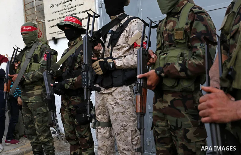 Palestinian militants of the National Resistance brigades, the armed wing of the Democratic Front for the Liberation of Palestine (DFLP), stand outside al-Shifa hospital after the arrival of the body of a Palestinian fis...