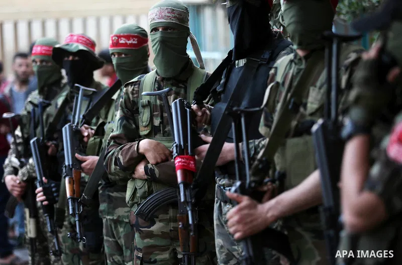 Palestinian militants of the National Resistance brigades, the armed wing of the Democratic Front for the Liberation of Palestine (DFLP), stand outside al-Shifa hospital after the arrival of the body of a Palestinian fis...