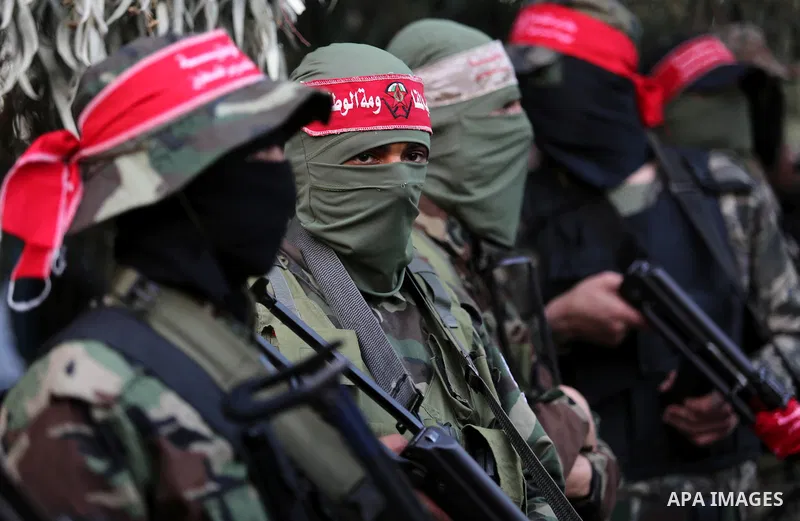Palestinian militants of the National Resistance brigades, the armed wing of the Democratic Front for the Liberation of Palestine (DFLP), stand outside al-Shifa hospital after the arrival of the body of a Palestinian fis...