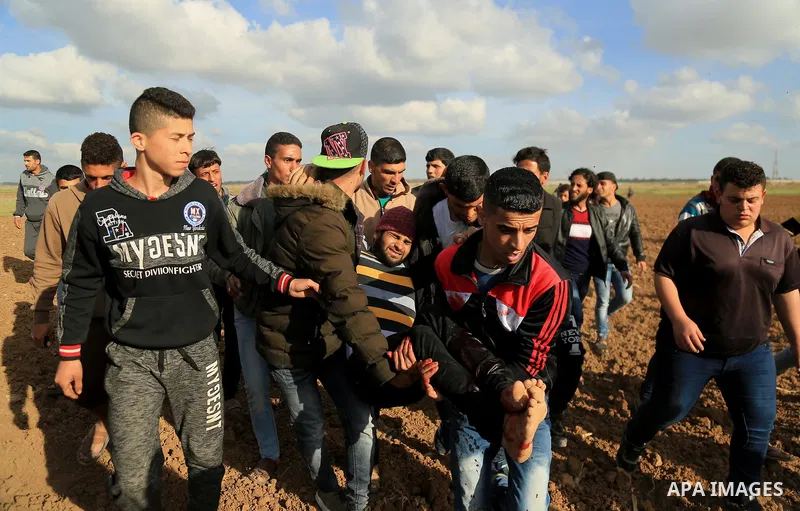 A wounded Palestinian is evacuated during clashes with Israeli security forces in response to the United States' decision to recognize Jerusalem as the Capital of Israel near the border with Israel in east of Gaza city o...