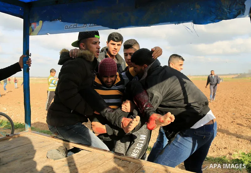 A wounded Palestinian is evacuated during clashes with Israeli security forces in response to the United States' decision to recognize Jerusalem as the Capital of Israel near the border with Israel in east of Gaza city o...