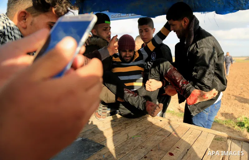 A wounded Palestinian is evacuated during clashes with Israeli security forces in response to the United States' decision to recognize Jerusalem as the Capital of Israel near the border with Israel in east of Gaza city o...