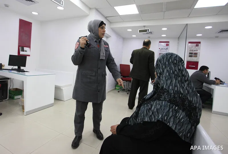 A Palestinian woman security guard from Secure Land company for security and logistics services takes part in a work day at bank of Palestine in Gaza City on March 19, 2018. Secure land is the first security company for...