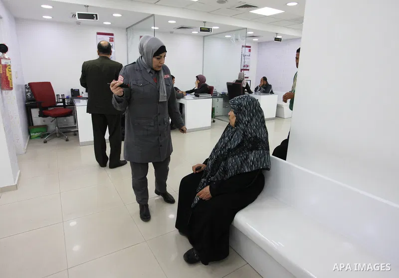 A Palestinian woman security guard from Secure Land company for security and logistics services takes part in a work day at bank of Palestine in Gaza City on March 19, 2018. Secure land is the first security company for...