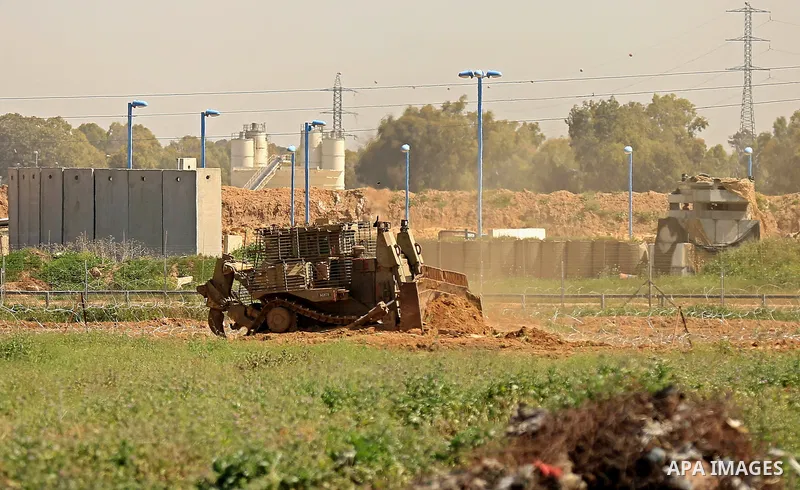 Israeli military vehicles are seen near the border fence between Israel and east of Gaza city on March 21, 2018 . Photo by Dawoud Abo Alkas
