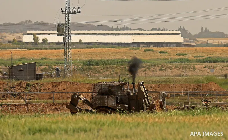 Israeli military vehicles are seen near the border fence between Israel and east of Gaza city on March 21, 2018 . Photo by Dawoud Abo Alkas
