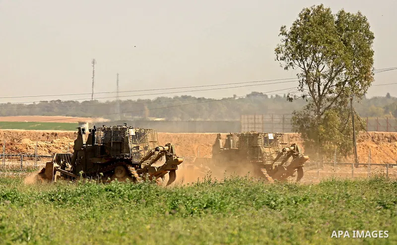 Israeli military vehicles are seen near the border fence between Israel and east of Gaza city on March 21, 2018 . Photo by Dawoud Abo Alkas