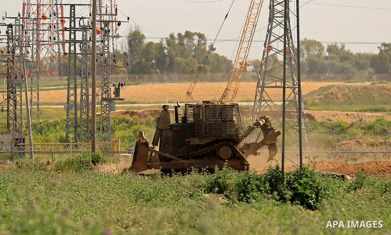 Israeli military vehicles are seen near the border fence between Israel and east of Gaza city on March 21, 2018 . Photo by Dawoud Abo Alkas
