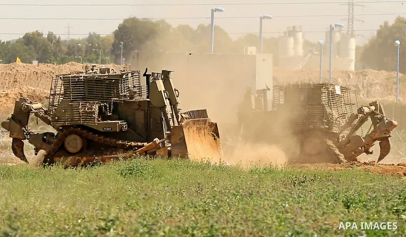 Israeli military vehicles are seen near the border fence between Israel and east of Gaza city on March 21, 2018 . Photo by Dawoud Abo Alkas