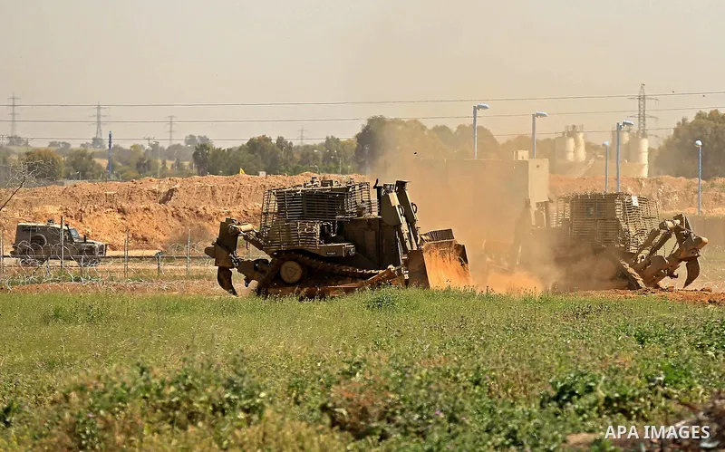 Israeli military vehicles are seen near the border fence between Israel and east of Gaza city on March 21, 2018 . Photo by Dawoud Abo Alkas