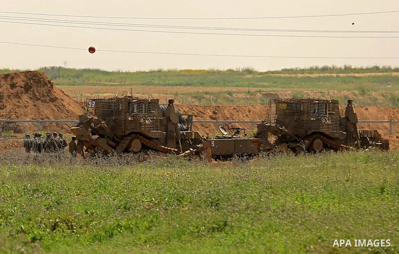 Israeli military vehicles are seen near the border fence between Israel and east of Gaza city on March 21, 2018 . Photo by Dawoud Abo Alkas