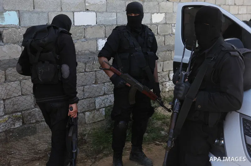 Fighters of Ezz al-Din Al Qassam Brigades, the armed wing of the Hamas movement stand guard after a raid that resulted in the arrest of a suspect in the recent bombing that targeted the visiting Palestinian Prime Ministe...