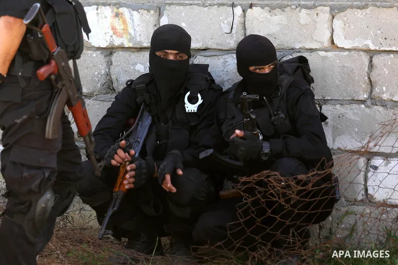 Fighters of Ezz al-Din Al Qassam Brigades, the armed wing of the Hamas movement stand guard after a raid that resulted in the arrest of a suspect in the recent bombing that targeted the visiting Palestinian Prime Ministe...