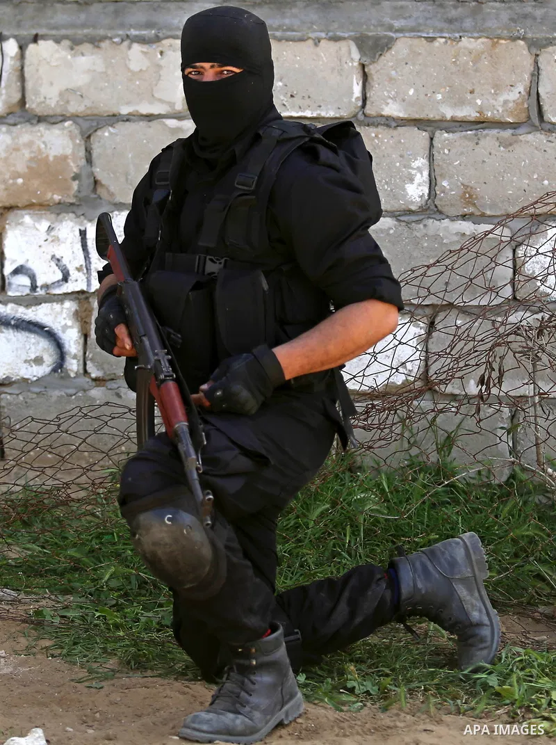 Fighters of Ezz al-Din Al Qassam Brigades, the armed wing of the Hamas movement stand guard after a raid that resulted in the arrest of a suspect in the recent bombing that targeted the visiting Palestinian Prime Ministe...