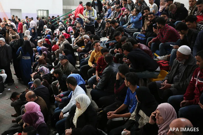Palestinians wait for travel permits to cross into Egypt through the Rafah border crossing after it was opened by Egyptian authorities for humanitarian cases, in Khan Yunis in the southern Gaza Strip on March 24, 2018. P...