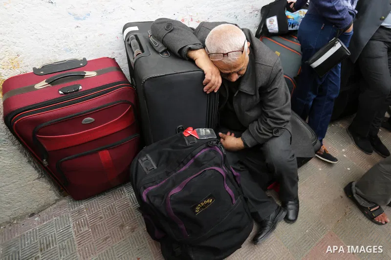 Palestinians wait for travel permits to cross into Egypt through the Rafah border crossing after it was opened by Egyptian authorities for humanitarian cases, in Khan Yunis in the southern Gaza Strip on March 24, 2018. P...