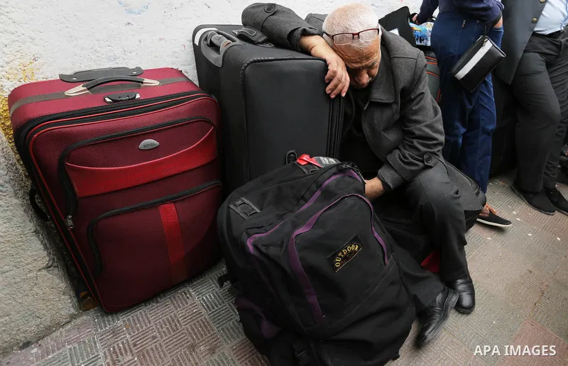 Palestinians wait for travel permits to cross into Egypt through the Rafah border crossing after it was opened by Egyptian authorities for humanitarian cases, in Khan Yunis in the southern Gaza Strip on March 24, 2018. P...