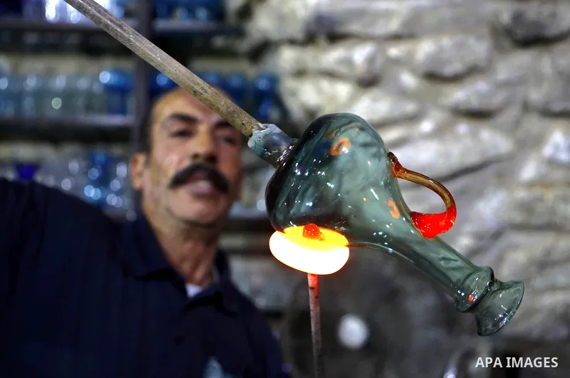 A Palestinian Yaacqoub al-Natsheh, professional glassblower who has been forming glass for over 40 years, works at his new workshop near the Ibrahimi Mosque, in the West Bank city of Hebron, March 25, 2018. Photo by Wisa...