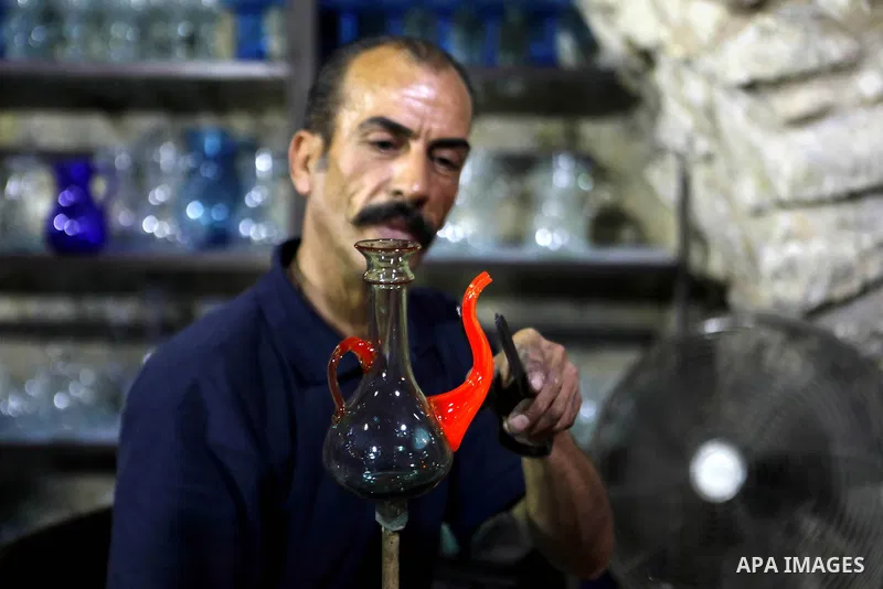 A Palestinian Yaacqoub al-Natsheh, professional glassblower who has been forming glass for over 40 years, works at his new workshop near the Ibrahimi Mosque, in the West Bank city of Hebron, March 25, 2018. Photo by Wisa...