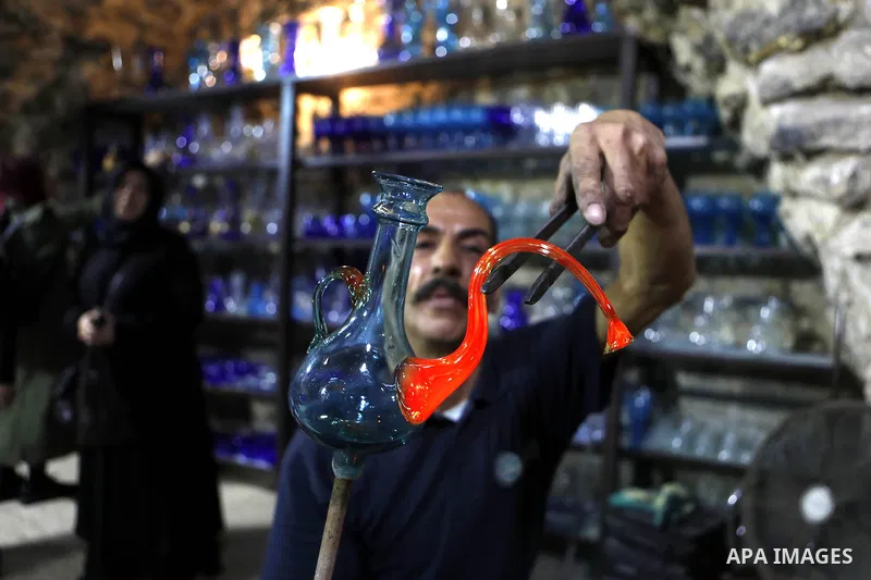 A Palestinian Yaacqoub al-Natsheh, professional glassblower who has been forming glass for over 40 years, works at his new workshop near the Ibrahimi Mosque, in the West Bank city of Hebron, March 25, 2018. Photo by Wisa...