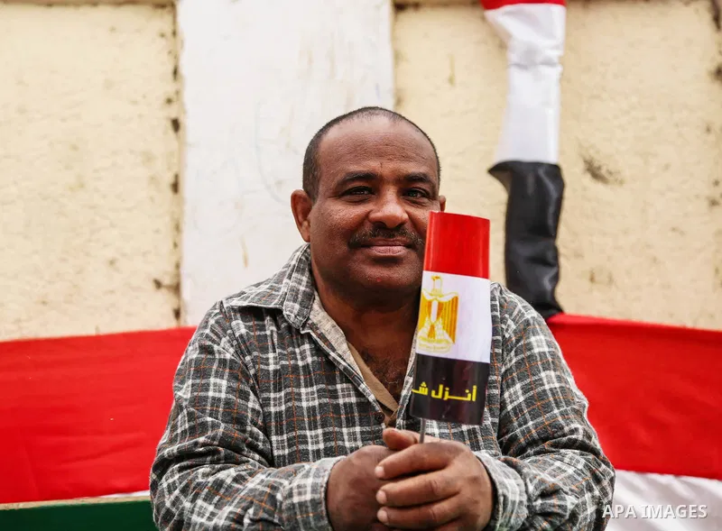 An Egyptian man holds the Egyptian flag on the first day of the 2018 Egyptian presidential elections, outside a polling station, in Cairo, Egypt, on March 26, 2018. Egyptians head to the polls in a three-day vote to choo...