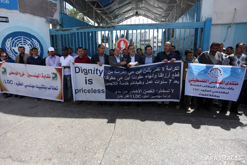 Palestinian engineers hold banners during a protest demanding their rights in front of the headquarters United Nations Relief and Works Agency (UNRWA) in Gaza city, March 27, 2018. Photo by Mahmoud Ajour