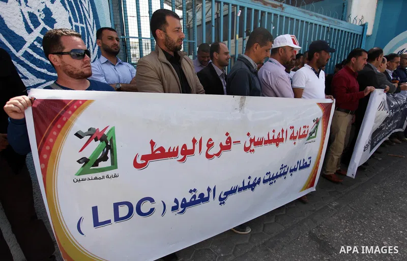 Palestinian engineers hold banners during a protest demanding their rights in front of the headquarters United Nations Relief and Works Agency (UNRWA) in Gaza city, March 27, 2018. Photo by Mahmoud Ajour