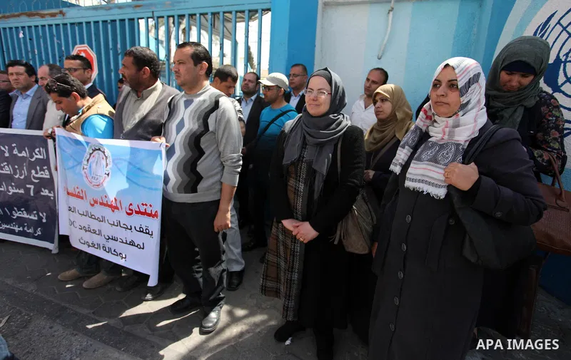 Palestinian engineers hold banners during a protest demanding their rights in front of the headquarters United Nations Relief and Works Agency (UNRWA) in Gaza city, March 27, 2018. Photo by Mahmoud Ajour