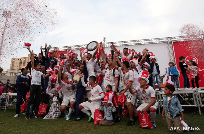 Palestinian players of Shabab Khan Younis football club celebrate with League Shield at Palestine stadium, in Gaza city on March 28, 2018. Photo by Mahmoud Ajour