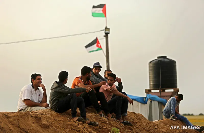 Palestinians sit near the Gaza-Israel border on the outskirts of Khan Yunis in the southern Gaza Strip on March 28, 2018. Protesters plan to call for the right of Palestinian refugees across the Middle East to return to...