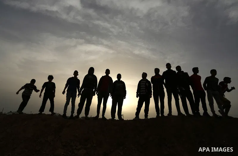 Palestinians stand near the Gaza-Israel border on the outskirts of Khan Yunis in the southern Gaza Strip on March 28, 2018. Protesters plan to call for the right of Palestinian refugees across the Middle East to return t...