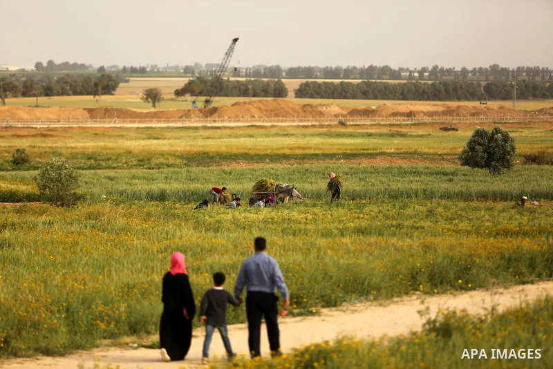 Palestinians walk and drive near the Gaza-Israel border on the outskirts of Khan Yunis in the southern Gaza Strip on March 28, 2018. Protesters plan to call for the right of Palestinian refugees across the Middle East to...