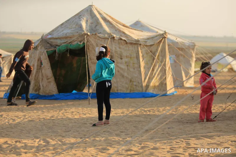 Paleatinians gather next to tents pitched by Palestinians on the Gaza border with Israel, east of Jabalia, on March 29, 2018, ahead of a six-week protest camp. The exceptional protest is dubbed "The Great March of Return...