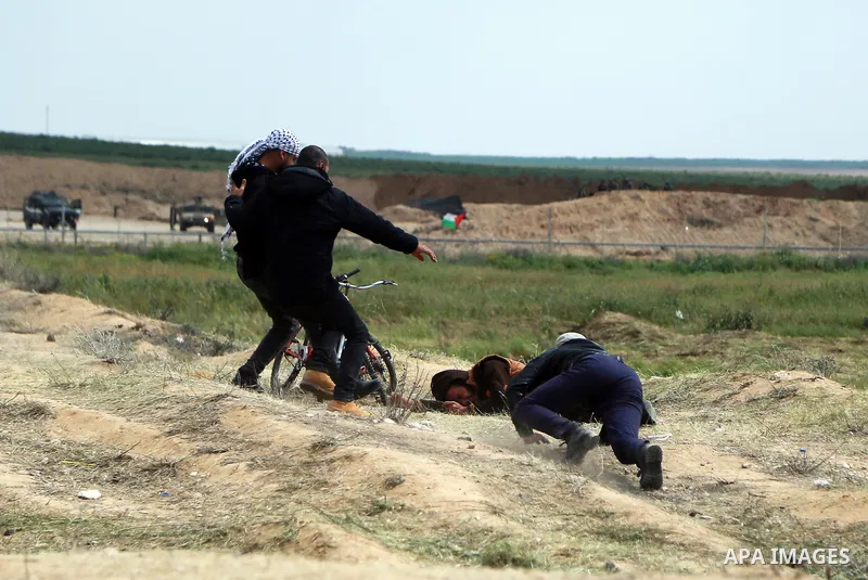 Palestinian protesters take cover during clashes with Israeli security forces in a tent city protest along the Israel border with Gaza, demanding the right to return to their homeland, east of Gaza City March 30, 2018. P...