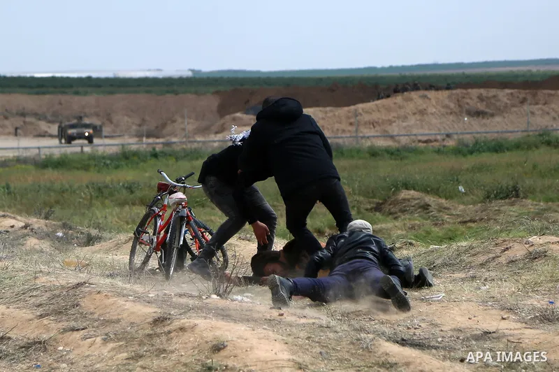 Palestinian protesters take cover during clashes with Israeli security forces in a tent city protest along the Israel border with Gaza, demanding the right to return to their homeland, east of Gaza City March 30, 2018. P...