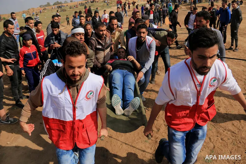 A wounded Palestinian is evacuated during clashes with Israeli security forces during a tent city protest along the Israel border with Gaza, demanding the right to return to their homeland, in al-Bureij in the center of...